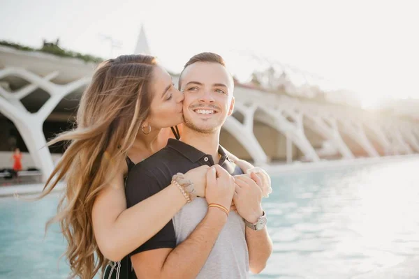 Smiling Girl Kissing Her Boyfriend Back Modern Urban Space Sunset — Stockfoto