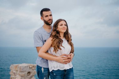 İspanyol bir adam akşamleyin İspanya 'daki Highland Park' ta esmer kız arkadaşının arkasından sarılıyor. Birkaç turist, Valencia 'da gün batımında deniz kenarında eğleniyorlar..