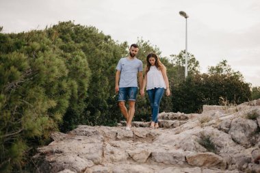 İspanyol bir adam, İspanya 'daki Highland Park' taki antik taş merdivenlerden kız arkadaşının inmesine yardım ediyor. Birkaç turist Valencia 'da gün batımında bir randevuda yürüyüş yaparken eğleniyorlar..