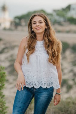 İspanyol bir kadın İspanya 'daki Highland Park' ın arka planında deniz feneriyle poz veriyor. Bir turist gün batımında Valencia 'da yürüyüş yapıyor..