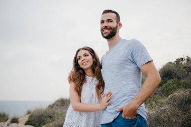 İspanyol bir adam akşam İspanya 'daki Highland Park' ta Latin kız arkadaşına sarılıyor. Birkaç turist, Valencia 'da gün batımında deniz kenarında eğleniyorlar..