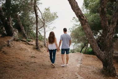 İspanya 'daki bir dağ parkında ormanlık tepeden denize inen İspanyol bir adamla Latin kız arkadaşının fotoğrafı. Valencia 'da iki turist eğleniyor.