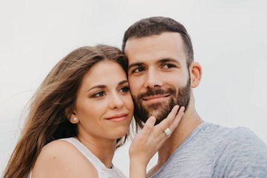 İspanya 'da bir dağ parkında kayalık deniz kıyısında birbirine sarılan İspanyol bir adamın ve gülümseyen kız arkadaşının yakın portresi. Valenci 'de bir çift mutlu turist