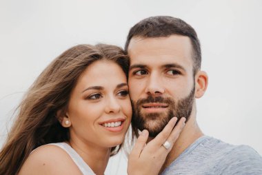 İspanya 'da bir dağ parkında kayalık deniz kıyısında birbirine sarılan İspanyol bir adamın ve gülümseyen kız arkadaşının yakın portresi. Valenci 'de bir çift mutlu turist