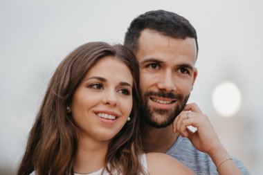 İspanya 'daki deniz fenerinde İspanyol erkek arkadaşının yüzünü okşayan Latin bir kızın yakın portresi. Valencia 'da bir çift gülümseyen turist.