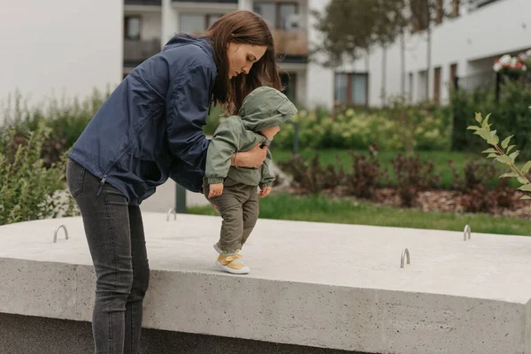 Uma Mãe Feliz Está Segurando Sua Filha Uma Capa Chuva — Fotografia de Stock