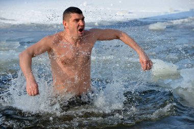 Kyiv, Ukraine - January 19, 2021 - Celebration of Epiphany in Kyiv. The orthodox believer dives into the icy water.
