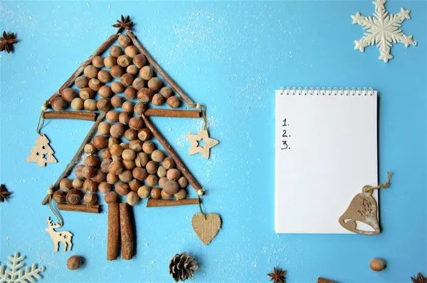 Planification du Nouvel An avec une feuille de papier propre pour l'écriture et un arbre de Noël fait de noix, cannelle, anis étoilé décoré de jouets naturels — Photo