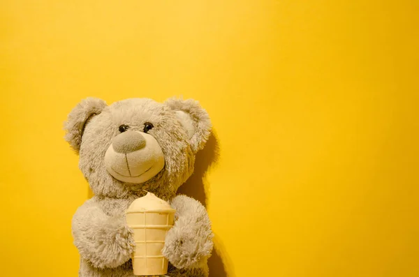 Sarı arka planda dondurmalı gri oyuncak oyuncak. Yazmak için yeri var.