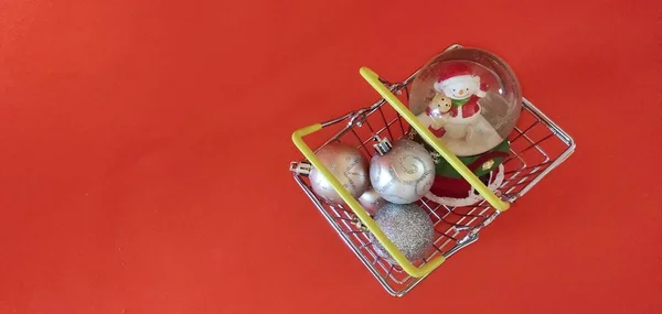 New Year layout view from the top on a red background, in the basket balls and a ball with a snowman — стоковое фото