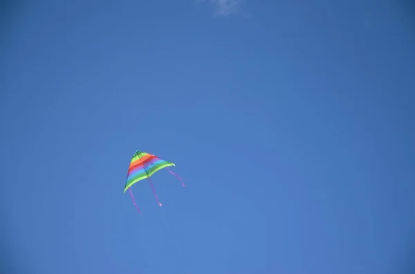 Красочный змей, летящий в голубом небе — стоковое фото