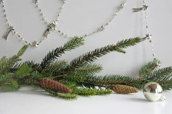 Composition du Nouvel An de branches d'épinette et de cônes décorés de boules d'argent et de guirlande — Photo