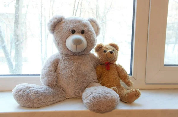 Dos osos de peluche en el alféizar de la ventana en un abrazo, el concepto de simpatía y amor — Foto de Stock