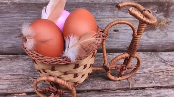 Chicken eggs in a basket with feathers, the concept of Easter — Stock Video