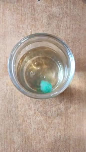 Киньте розчинну таблетку для фарбування яєць у банку з водою. підготовка до розмальовки яєць на Великдень . — стокове відео