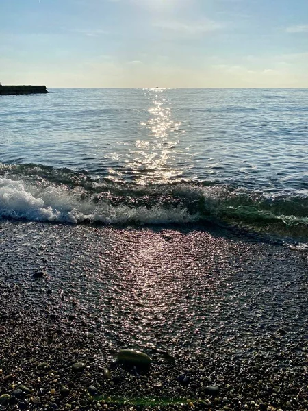 Puesta de sol en la orilla. El brillo del sol poniente en el agua —  Fotos de Stock
