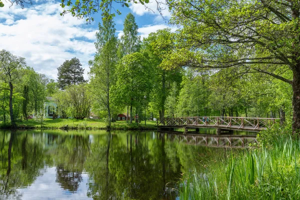 瑞典一个绿树成荫的公园里有一座木桥的池塘 — 图库照片