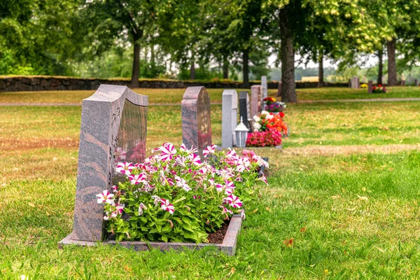 Reihe Von Grabsteinen Mit Bunten Blumen Auf Einem Gepflegten Friedhof — Stockfoto