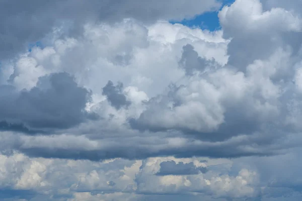 从乌云密布的天空后撤 浓密的灰白色夏季云彩和一些阳光穿过 — 图库照片