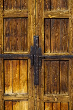Eski ahşap bir kapıyı kapatın. Eski demir menteşeleri ve sapı var.