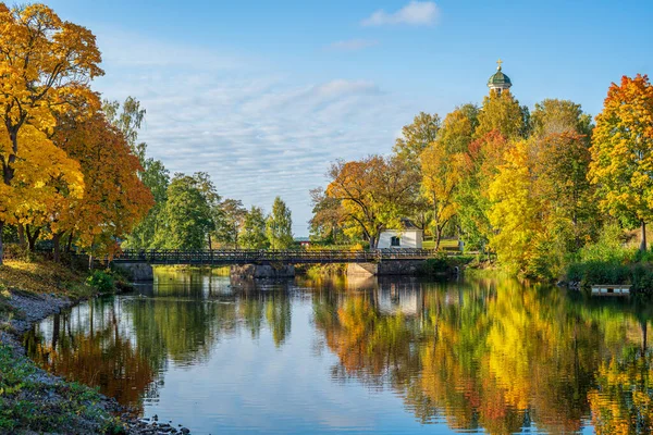 美丽的秋天景色来自瑞典 有一座桥穿过一条河 周围环绕着五彩缤纷的秋天树和一座教堂的塔楼 — 图库照片
