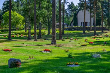 Yaz güneşinin altında bir sürü mezar ve renkli çiçeklerle güzel bir mezarlık.