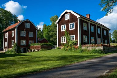 İsveç kırsalındaki tipik bir çiftliğin güzel yaz manzarası.