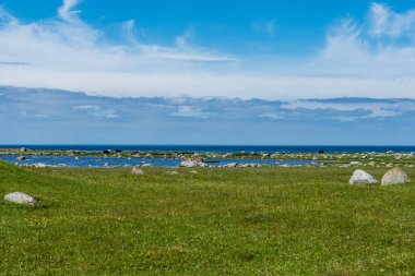 Oland 'ın güney ucunda güzel bir yaz manzarası ve okyanus yakınlarındaki bir arazide eski bir taş haç.