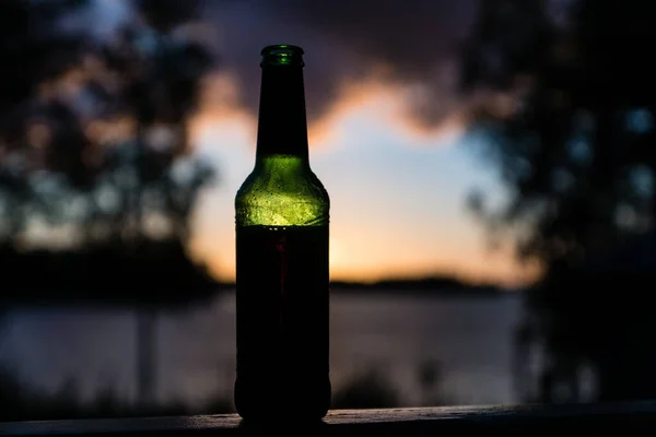 Bottiglia Birra Verde Piedi Davanti Sole Tramonto Con Nuvole Rosa — Foto Stock