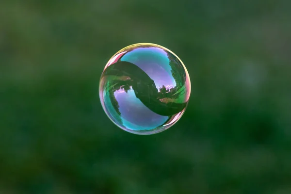 Close Van Vliegende Zeepbel Met Grote Reflecties Vliegen Groene Achtergrond — Stockfoto