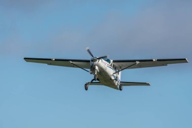 Parlak yaz güneşinde mavi gökyüzüne doğru uçan küçük bir pervane uçağının yakın görüntüsü