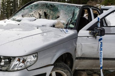 Gümüş renkli çalıntı araba, toprak bir yolun kenarına çarpıp atılmış. Tamamen tahrip edilmiş ve harap olmuş..