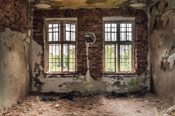 一间被关闭的旧精神病院的牢房里 厚重的砖墙上涂着一层油漆 窗前挂着铁条 — 图库照片
