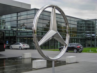 Sindelfingen üretim fabrikasının dışında büyük krom bir Mercedes logosu var. Sindelfingen, Almanya, 2017-10-12