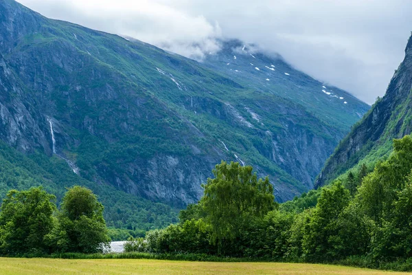 Dolina Norwegii Bujnymi Zielonymi Drzewami Pomiędzy Dwoma Pokrytymi Drzewami Szczytami — Zdjęcie stockowe