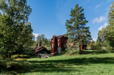 İsveç 'te güzel bir yaz gününde yemyeşil bir ortamda yüz yıllık demircilik binası.