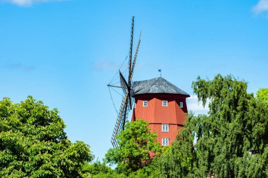 İsveç 'in Strangnas şehrinde bulunan ahşaptan yapılmış çok büyük bir yel değirmeni. 1855 'te inşa edilmiş. Güneşin altında yemyeşil bir ortamda duruyor, mavi bir yaz gökyüzüne karşı.