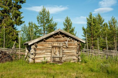 İsveç 'in kuzeyinde terk edilmiş eski bir tepede kerestelerden yapılmış eski ve solgun bir çiftlik kulübesi. Güneşli ve mavi gökyüzü ile güzel bir yaz gününde