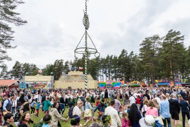 İsveç geleneklerine göre insanlar yaz ortasını kutluyor ve meyhane direğinin etrafında el ele tutuşup dans ediyorlar.