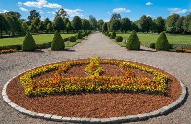 Stromsholm şatosunun simetrik bahçesinde, turuncu ve sarı çiçekli büyük bir kraliyet tacı şeklinde güzel bir çiçek tarlası..