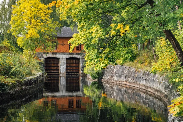 运河从一个有木门和秋天五颜六色树木的老水电站沿河而来 — 图库照片
