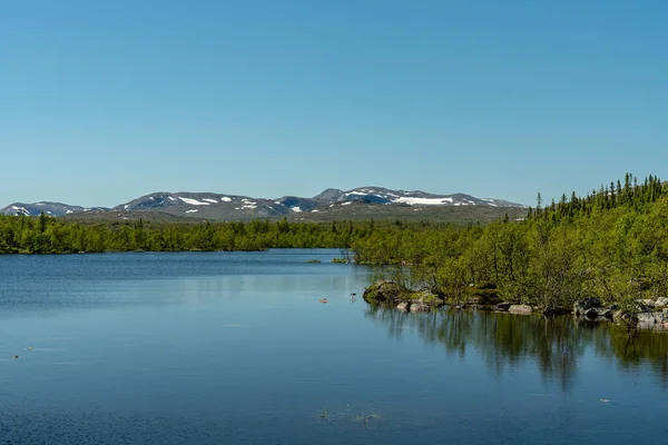 햇살이 내리쬐는 아름다운 여름날 산봉우리들 과작은 호수가 스웨덴 지대나 협만의 — 스톡 사진