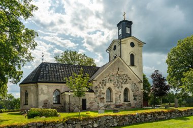 İsveç, Lundby 'de bulunan ortaçağ kilisesi. Parlak yaz güneşinde ve bulutlu gökyüzünde