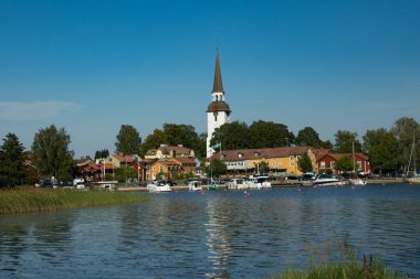 İsveç 'in Mariefred kentindeki kilise manzarası ve küçük tekne limanı..