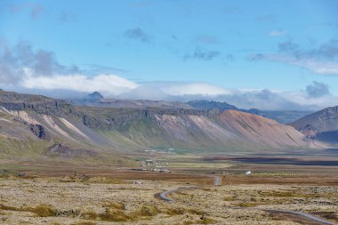 İzlanda 'dan güzel manzara dağ sırası ve 1. Yol ile küçük bir köyü geçiyor.