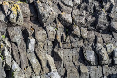 Güneş ışığında eritilmiş kaya bazalt ya da lav duvarı soyut bir model oluşturur.