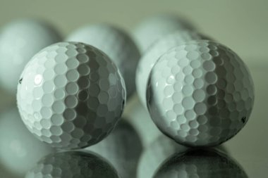 Bir tabak camda yansıyan beyaz golf toplarını kapat.