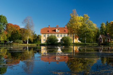 Doğanın büyük sonbahar renklerine sahip İsveç malikanesinin harika manzarası