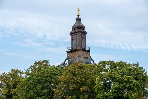 Kirchturm Ragt Über Herbstliche Bäume Vor Blauem Himmel — Stockfoto