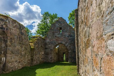 İsveç 'teki eski bir ortaçağ kilisesinin güzel yaz manzarası. Parlak güneş ışığı, yemyeşil ağaçlar ve mavi bir gökyüzü.
